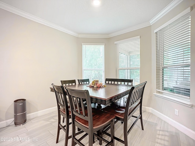 dining room featuring a wealth of natural light, crown molding, and baseboards