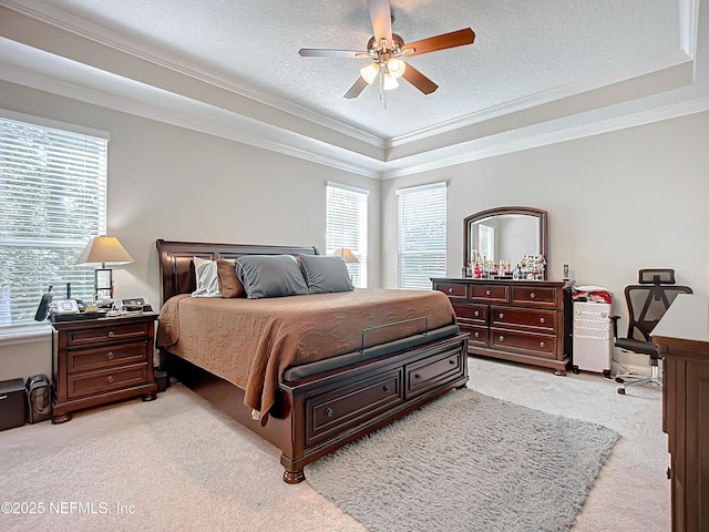 bedroom with a tray ceiling, multiple windows, a textured ceiling, and ornamental molding