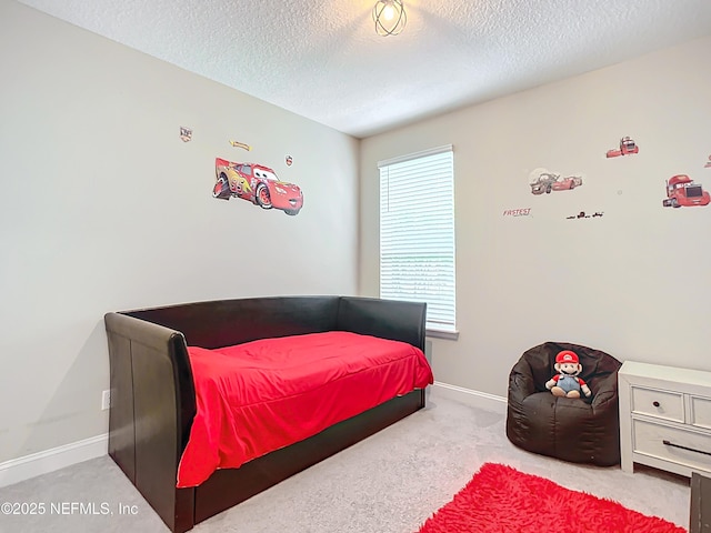 carpeted bedroom featuring a textured ceiling and baseboards