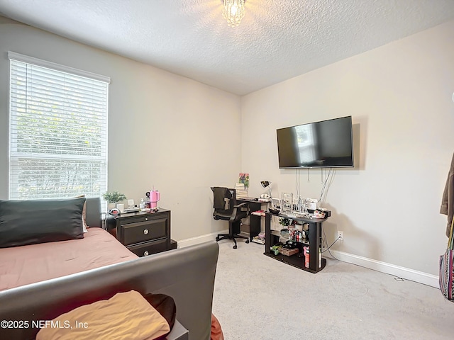 carpeted bedroom featuring a textured ceiling and baseboards