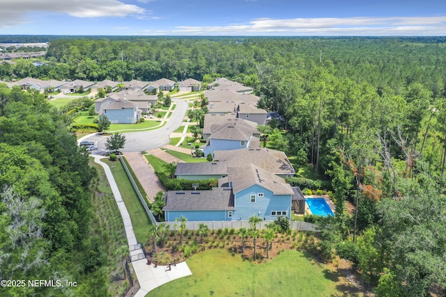 drone / aerial view featuring a forest view and a residential view