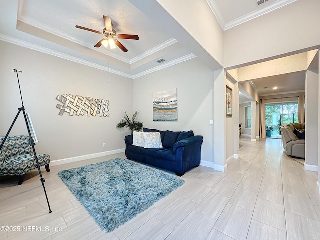 living room with visible vents, crown molding, a raised ceiling, and baseboards