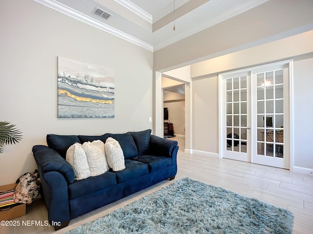 living room with visible vents, baseboards, ornamental molding, french doors, and a raised ceiling