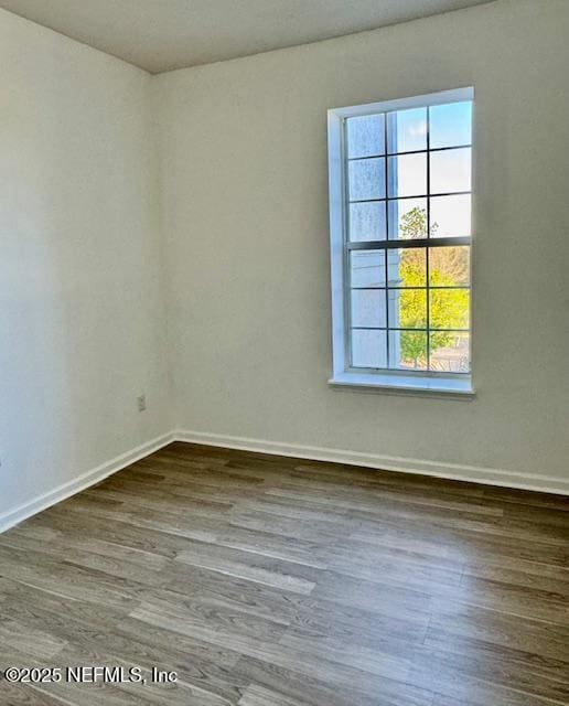 empty room featuring baseboards and wood finished floors