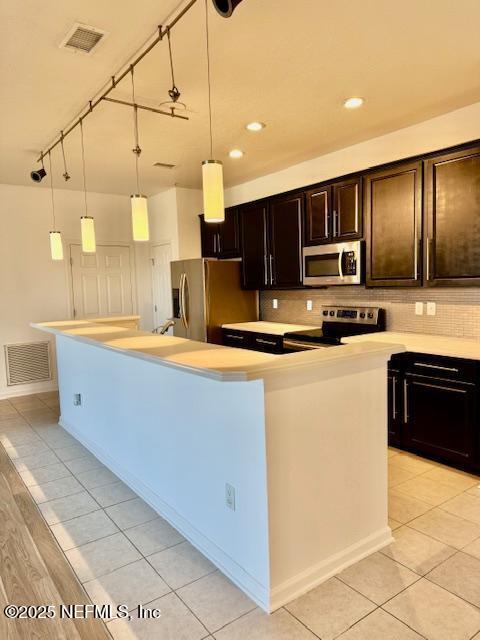 kitchen featuring an island with sink, visible vents, stainless steel appliances, and light countertops