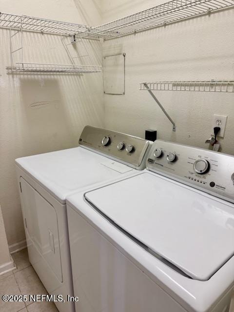 clothes washing area with light tile patterned floors, laundry area, and independent washer and dryer