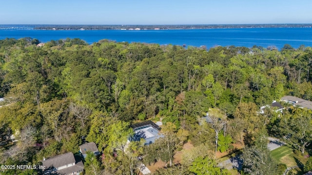 drone / aerial view with a forest view and a water view