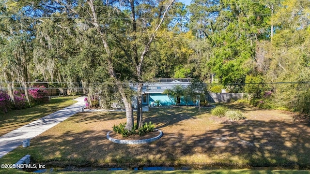 view of front of home with concrete driveway and fence