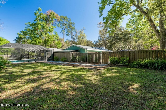 view of yard with glass enclosure, a fenced backyard, and a fenced in pool