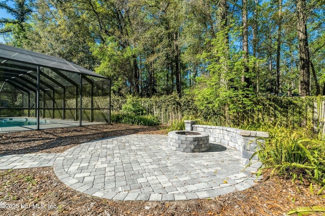 view of patio with an outdoor pool, glass enclosure, and a fire pit