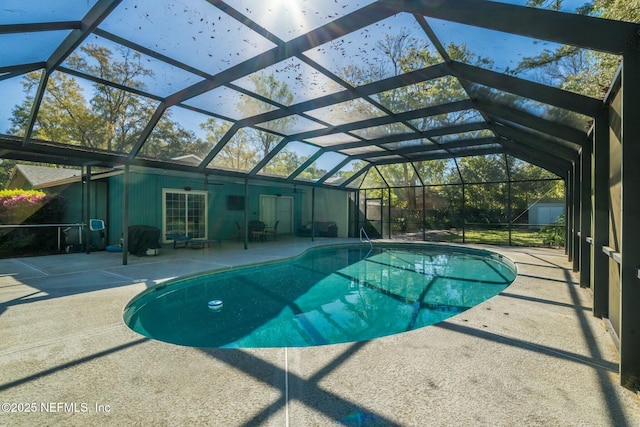 outdoor pool featuring glass enclosure and a patio