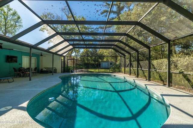 pool with a patio, an outbuilding, and a lanai