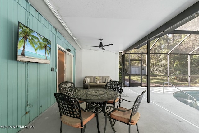 view of patio with glass enclosure and a ceiling fan