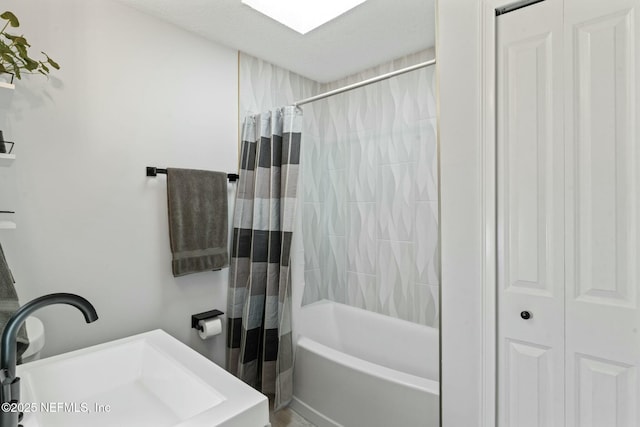 bathroom with a sink and shower / bath combo with shower curtain