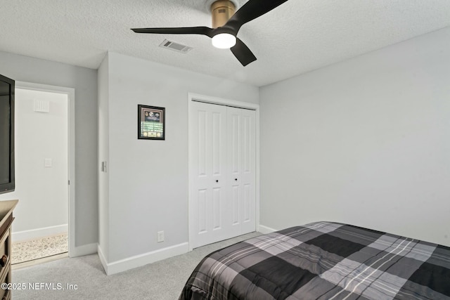 bedroom featuring a closet, visible vents, a textured ceiling, and carpet floors