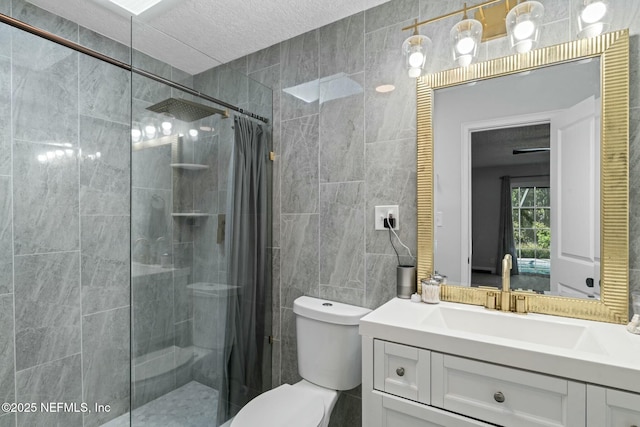 bathroom with toilet, a textured ceiling, tile walls, a shower stall, and vanity