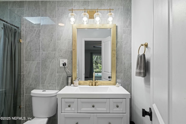 full bathroom with toilet, tile walls, and vanity