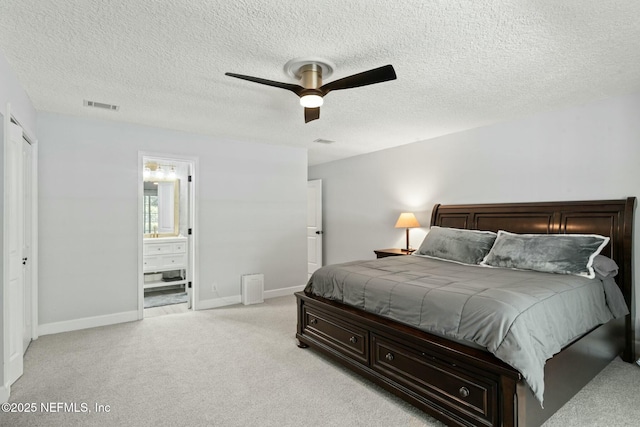 bedroom with visible vents, light carpet, baseboards, and ensuite bath