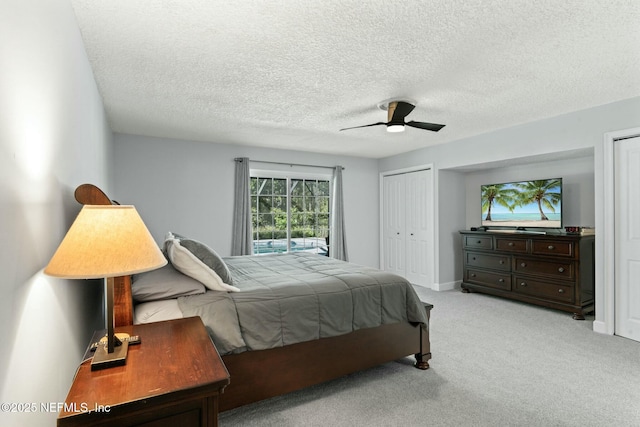 bedroom with light carpet, baseboards, a textured ceiling, and a ceiling fan