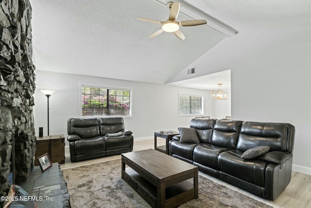 living room featuring visible vents, vaulted ceiling with beams, ceiling fan with notable chandelier, wood finished floors, and a textured ceiling