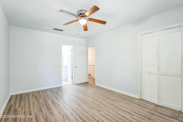 unfurnished bedroom with visible vents, baseboards, ensuite bathroom, wood finished floors, and a closet