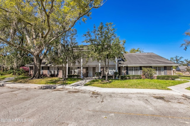 townhome / multi-family property featuring brick siding and a front lawn