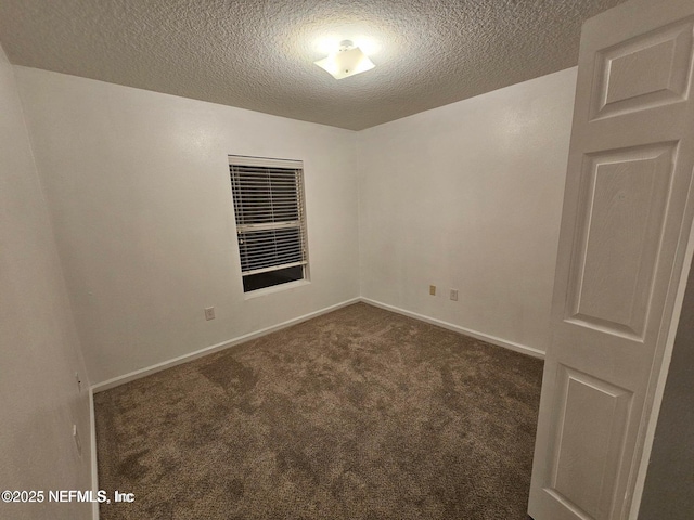 carpeted spare room featuring baseboards and a textured ceiling