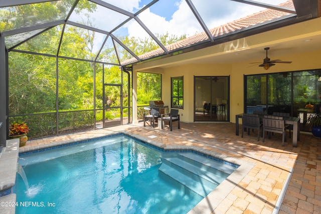 outdoor pool with a patio area, a lanai, and a ceiling fan