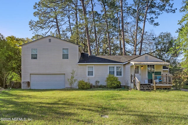 back of property featuring a lawn, an attached garage, and a shingled roof