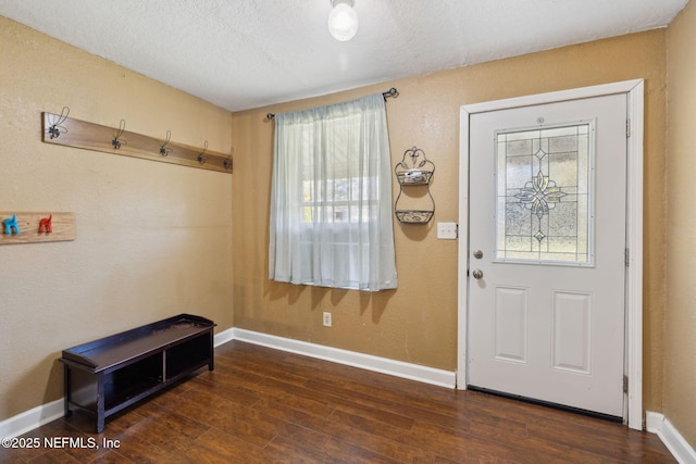 foyer entrance with baseboards, a textured ceiling, and dark wood finished floors