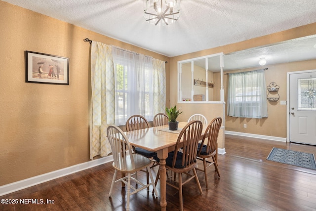 dining space featuring baseboards, a textured ceiling, and hardwood / wood-style flooring