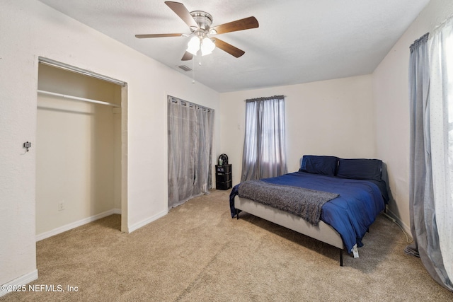 carpeted bedroom with visible vents, baseboards, and ceiling fan