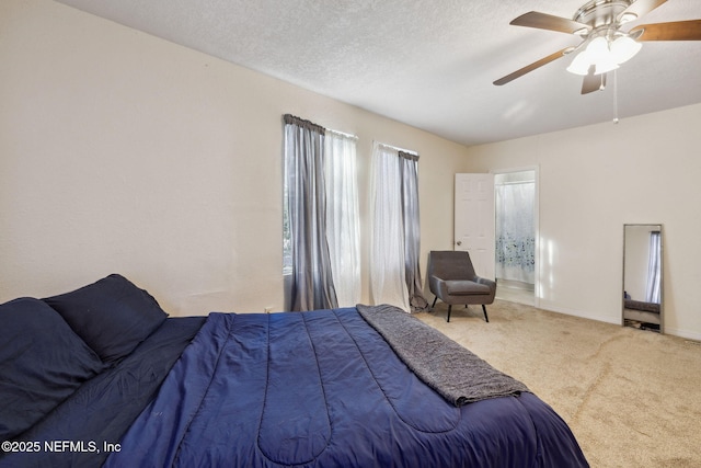 carpeted bedroom with connected bathroom, a textured ceiling, baseboards, and a ceiling fan