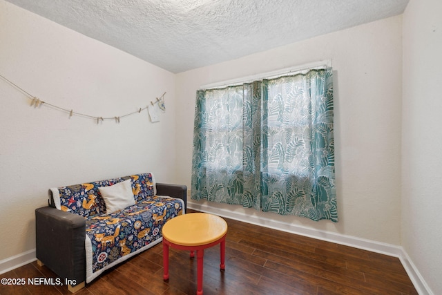 sitting room featuring wood finished floors, baseboards, and a textured ceiling