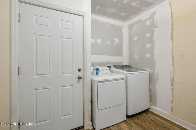 washroom featuring washer and dryer, baseboards, dark wood-style floors, and laundry area