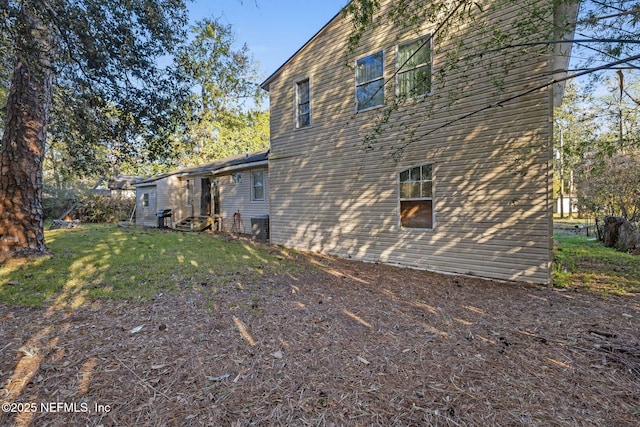 view of side of property featuring a lawn and entry steps