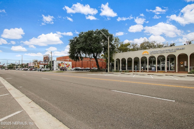 view of road with sidewalks, curbs, and street lighting