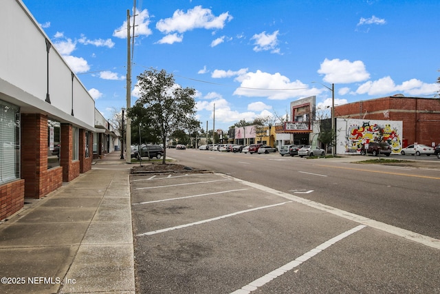 view of road featuring curbs, sidewalks, and street lighting