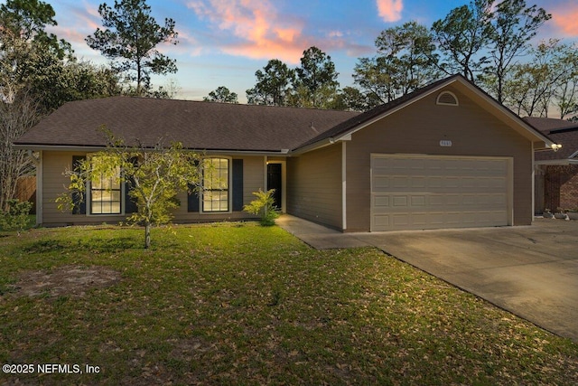 ranch-style home featuring a front yard, an attached garage, and driveway