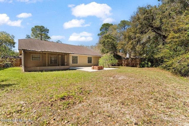 back of house featuring a patio, a yard, fence, and an outdoor fire pit