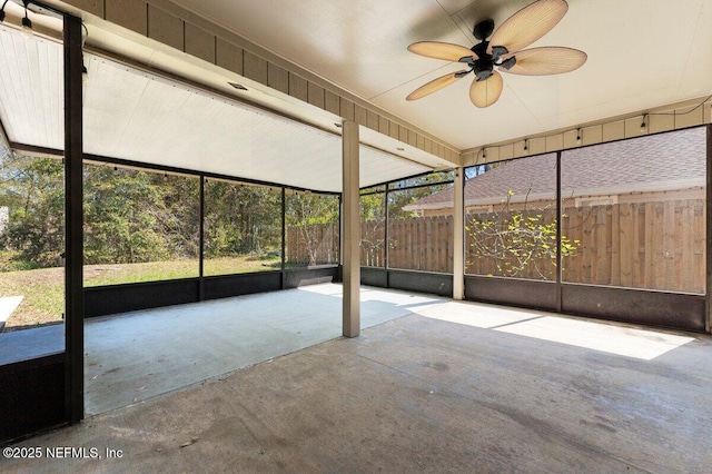 unfurnished sunroom featuring a ceiling fan