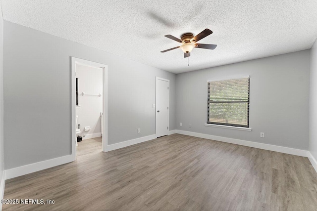 empty room featuring baseboards, a textured ceiling, wood finished floors, and a ceiling fan