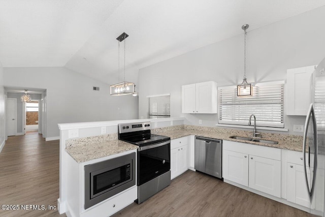 kitchen with a sink, stainless steel appliances, a peninsula, and white cabinetry