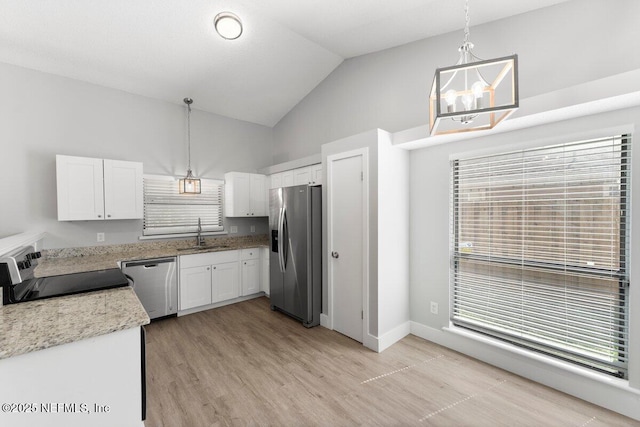 kitchen featuring decorative light fixtures, stainless steel appliances, light wood-style floors, white cabinetry, and a sink