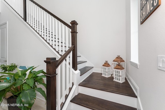 stairway with baseboards and wood finished floors