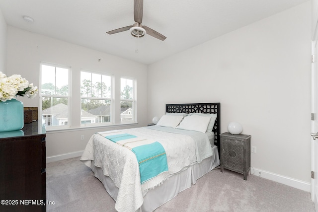 carpeted bedroom featuring a ceiling fan and baseboards