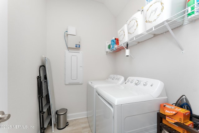 clothes washing area with electric panel, baseboards, laundry area, and washing machine and clothes dryer