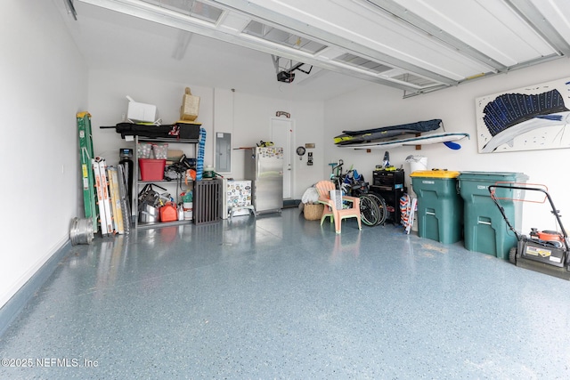 garage with electric panel, a garage door opener, freestanding refrigerator, and baseboards