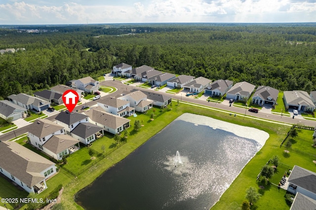 aerial view featuring a residential view, a wooded view, and a water view