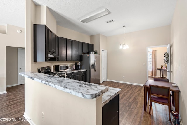 kitchen with visible vents, extractor fan, pendant lighting, stainless steel appliances, and dark wood-style flooring